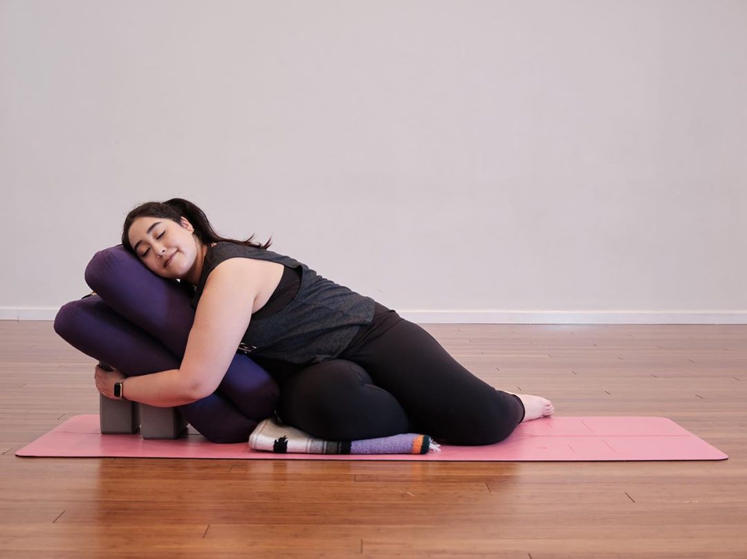 posture yoga restauratif sur le coté couverture briques