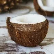Une demi noix de coco sur une table en bois