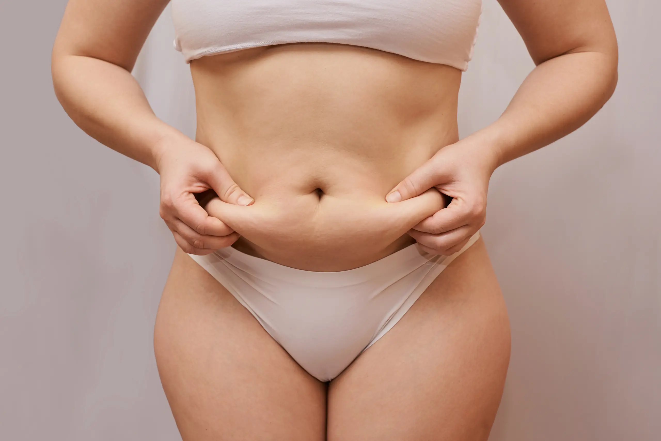 Image montrant une silhouette féminine avec des plis et des irrégularités sur la zone du ventre, illustrant les effets de la cellulite et comment l'éliminer.